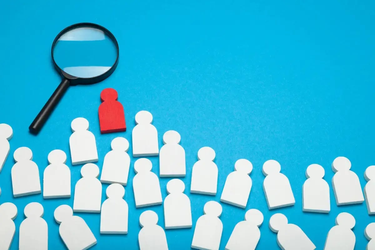 Cost of a bad hire graphic showing employee icons, a magnifying glass and a highlighted red employee icon