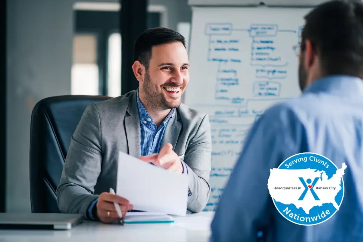 Business manager interviewing a job candidate while discussing hiring out-of-state employees and multi-state workforce requirements.