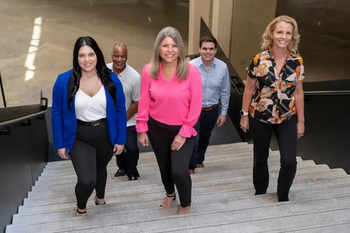 Working women of various ages climbing stairs in office building.