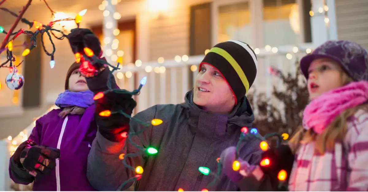 Family following Christmas light safety tips from Axcet HR Solutions while decorating for the holidays