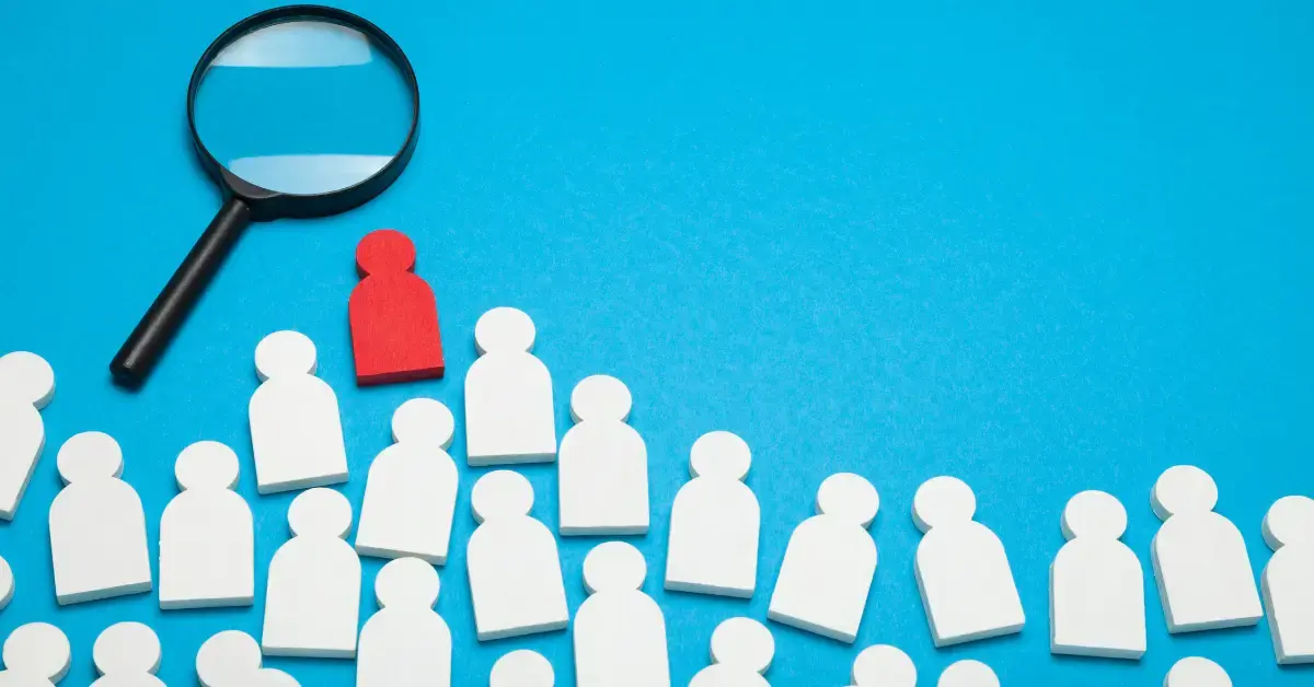 Cost of a bad hire graphic showing employee icons, a magnifying glass and a highlighted red employee icon