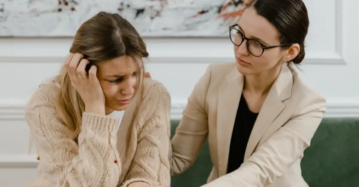 Manager comforting an employee affected by domestic violence in the workplace during a private conversation