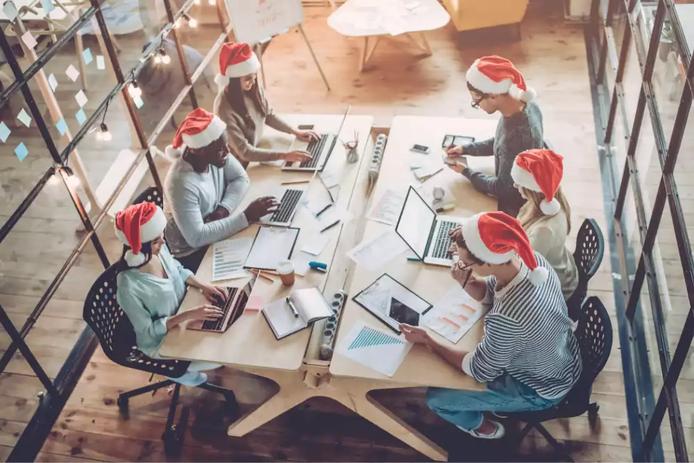 small business employees working while wearing santa hats